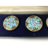 A cased set of six enamel buttons decorated with f