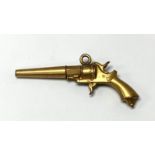 A yellow metal watch key in the form of a revolver