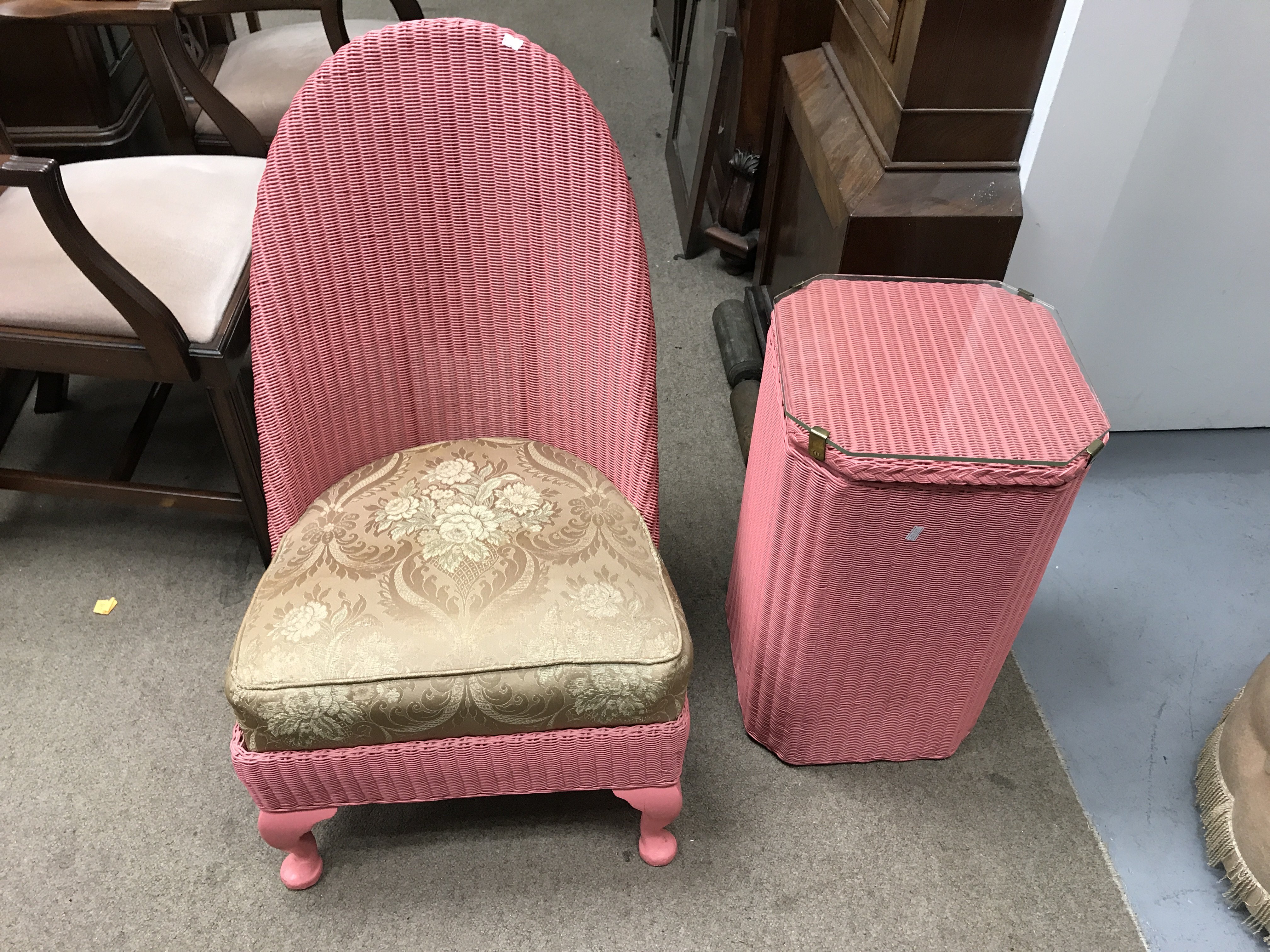 A Lloyd loom chair and linen basket with a carved