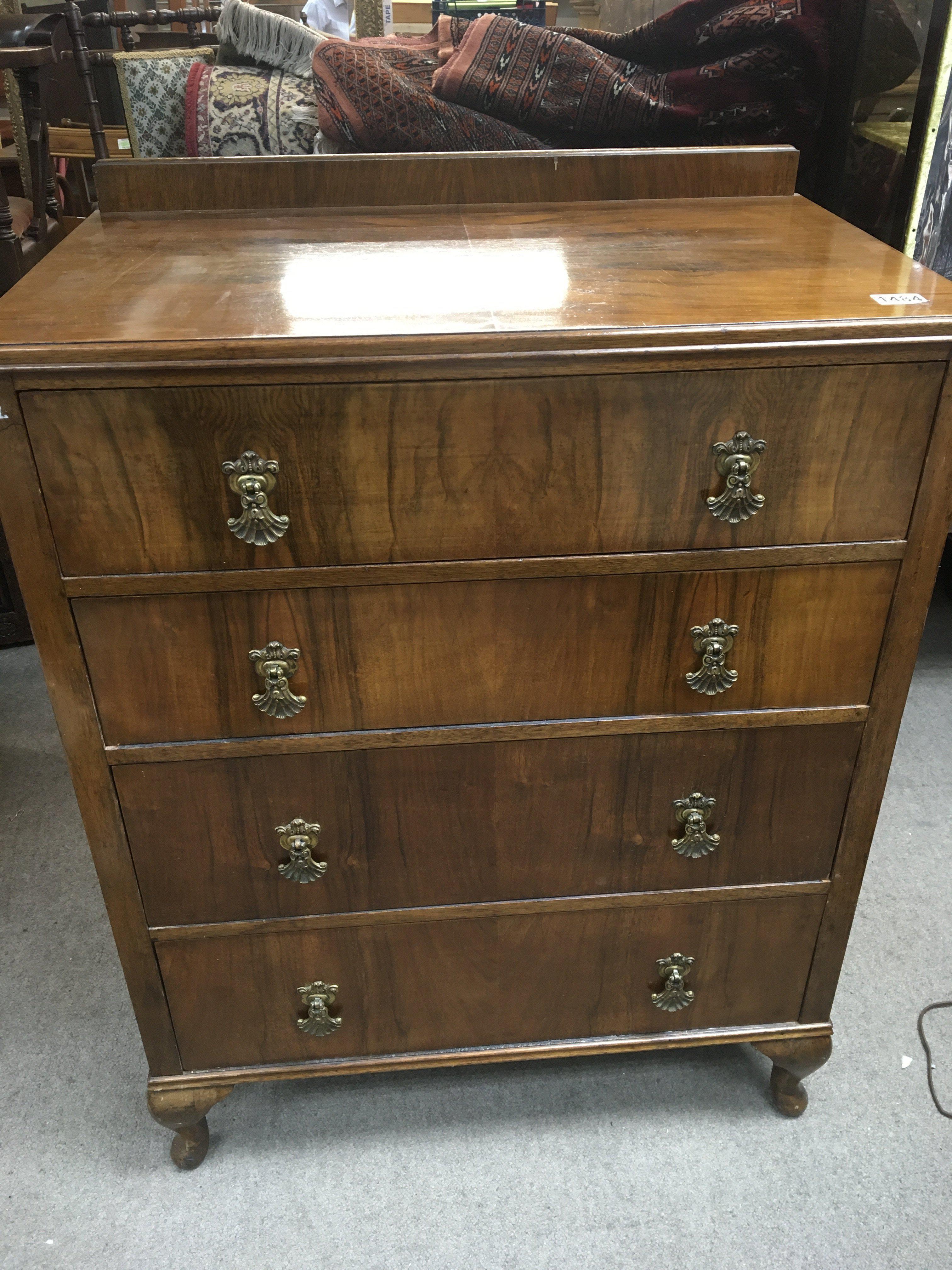 A walnut chest of drawers fitted with four long dr