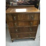 A walnut chest of drawers fitted with four long dr