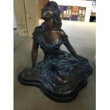 A Art nouveau style figure in the form of a seated maiden l