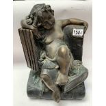 A cast bronze figure-of a child asleep on a book,