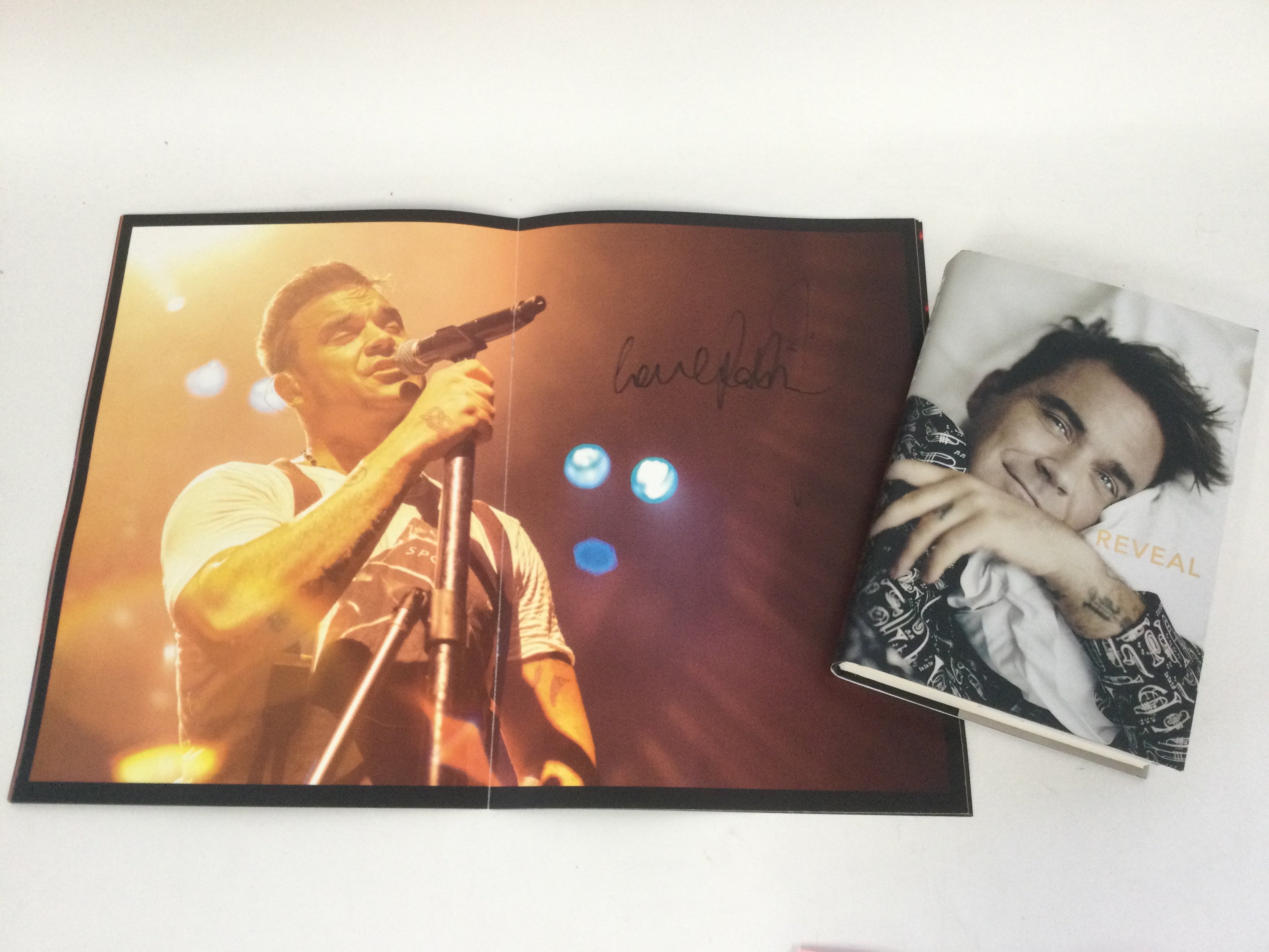A signed Robbie Williams book 'Reveal' together wi