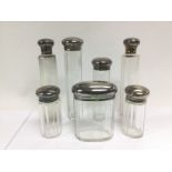 Seven silver topped glass perfume bottles. Shipping category D.