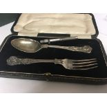 A silver spoon and folk in a fitted case and a qua