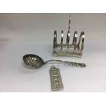 A silver toast rack and a silver pendant and sugar