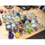 A large collection of various glass paperweights i
