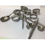 A silver caddy spoon together with other spoons na