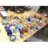 A large collection of various glass paperweights i