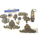 A quantity of military cap badges, pins etc. inclu