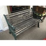 A green painted and wooden slats garden seat.