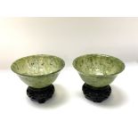A pair of turned spinach jade bowls with 2 small c
