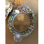 A Dresden oval mirror with taxied flower heads lan