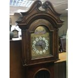 A walnut long case clock with an elaborate dial an