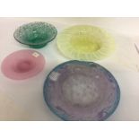 A collection of four shallow art glass dishes.