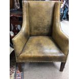 A childs leather wing back chair in the Geor