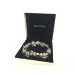 A Pandora bracelet with numerous charms , postage