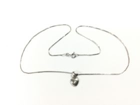 A white gold diamond set heart pendant on a white