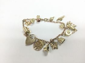 A 9ct gold charm bracelet with a diamond cut belch