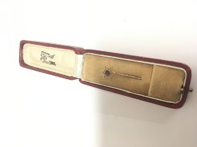 An 18carat gold stick pin set with a pink sapphire