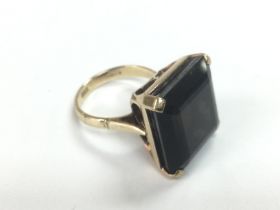 A 9ct gold ring set with a single smokey quartz st
