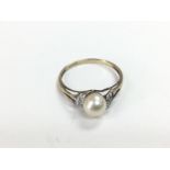 A 9ct gold eimg set with a central cultured pearl