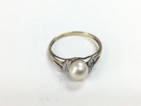 A 9ct gold eimg set with a central cultured pearl