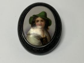 A porcelain and phenolic vintage brooch. (A)