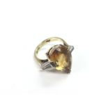 A 14k gold ring set with a central tear shaped cit