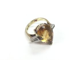 A 14k gold ring set with a central tear shaped cit