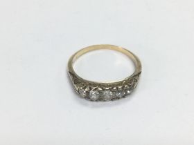 A gold ring set with a row of five old cut diamond