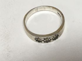 A white metal ring set with three CZ stones. Weigh