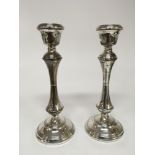 A pair of silver candle sticks with shaped stems a