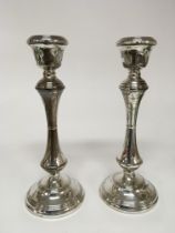 A pair of silver candle sticks with shaped stems a