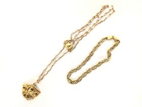 A 9ct gold mask pendant on chain and a 9ct gold br