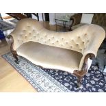 A Victorian walnut sofa with a shaped back button