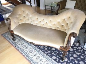 A Victorian walnut sofa with a shaped back button