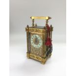 A brass cased carriage clock with engraved front.