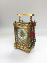 A brass cased carriage clock with engraved front.