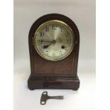 An eight day inlaid mahogany mantle clock, approx height 26cm. Comes supplied with key. Shipping