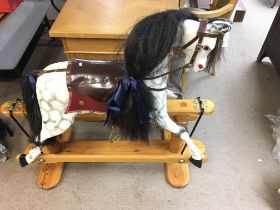 A wooden rocking horse from circa 2000s. Approx 110cm long and 100cm high. Postage D.