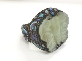 A large silver and jade bangle carved in the form