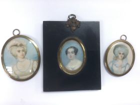 Three portrait miniatures of ladies, one in an ebo