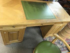 An oak pedestal desk with green leather centre and matching chair. Desk is approx 150cm wide by 70