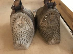 A pair of carved and metal stirrups.