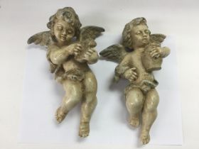 A pair of plaster cherubs ornaments, approx height