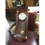 A reproduction wall clock and a brass clock under a dome (2). Shipping category D.