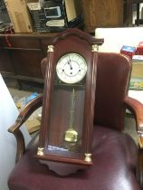 A reproduction wall clock and a brass clock under a dome (2). Shipping category D.