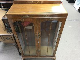A lacquer cabinet featuring oriental style artwork